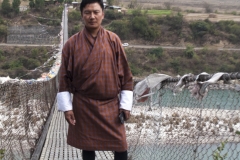 Lakey Drakpa posing on the suspension bridge in Punakha